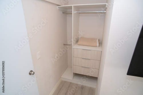 Photos Interior of a modern built-in closet with a storage system and drawers for clothes