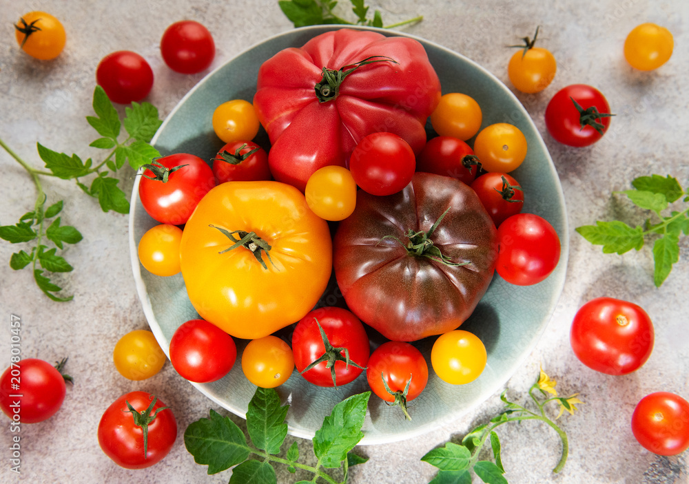 Obraz premium Fresh farm tomatoes displaying colorful variety on a plate