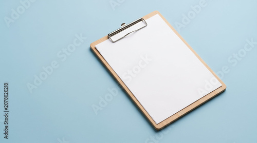 Blank clipboard mockup in minimalist flat lay style, natural wood and pastel blue tones, document template for list making or medical checklist with copy space