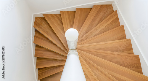 Spiral wooden staircase with light fixture in center