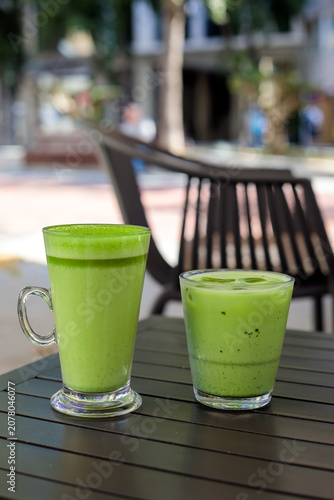 Fotografie Hot matcha latte in tall glass mug and iced matcha latte in short glass with ice