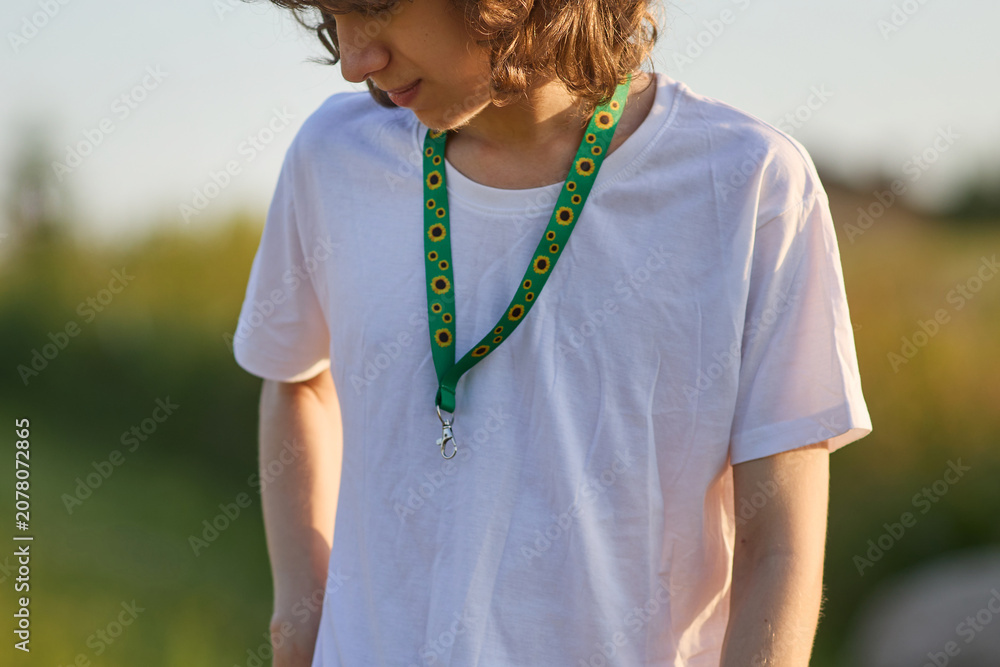 Fototapeta premium Person wearing green sunflower lanyard for hidden disability awareness