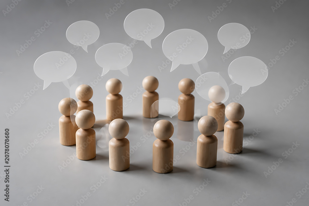 Obraz premium Wooden peg figures in a circle with speech bubbles, group communication and teamwork concept, collaborative discussion and social networking isolated on White Background ai