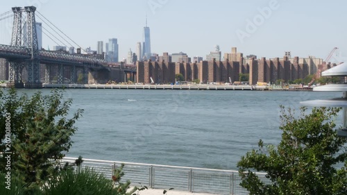 Williamsburg Bridge in Brooklyn, New York City, United States. Transport metallic bridge near Marcy Av subway station and Domino park in Williamsburg. World Trade Center skyscraper tower on Manhattan.