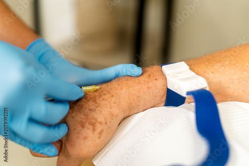 Obraz na płótnie Older adult arm receiving intravenous vitamin therapy