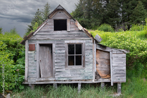 Abandoned, weathered building with stormy sky, Alaska