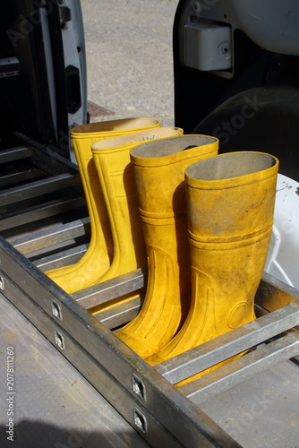 2 Paar Gummistiefel stehen zwischen den Sprossen einer Leiter auf einer Ladefläche