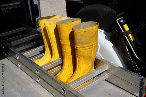 2 Paar Gummistiefel stehen zwischen den Sprossen einer Leiter auf einer Ladefläche