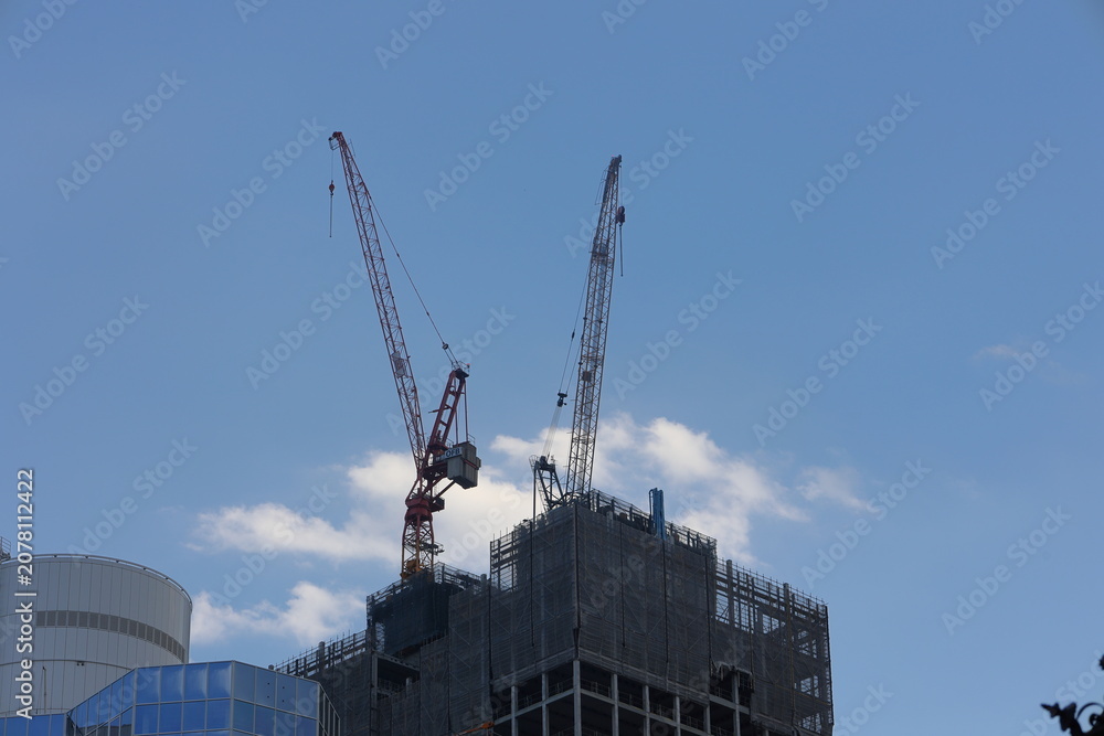 Fototapeta premium Hochhaus in Frankfurt mit einem Baukran auf dem Dach