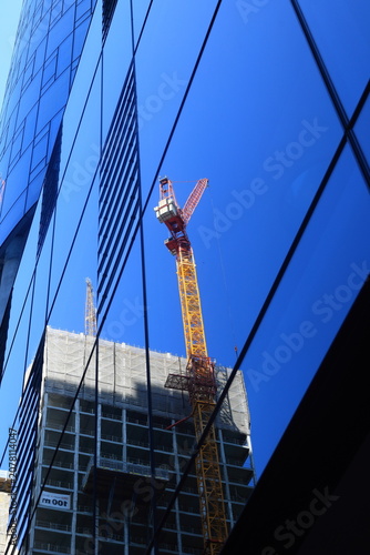 Baukran spiegelt sich in Frankfurt im Fenster von einem Hochhaus 