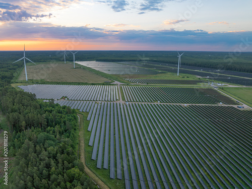 Quadro su tela Aerial view of a large solar farm with wind turbines at sunrise near Pope, Vents
