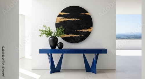 Minimalist entryway with blue console table and gold accent art.