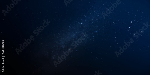 Obraz na plátne The Milky Way galaxy is seen from Earth, a celestial spectacle of shimmering stars and cosmic dust painting the deep blue night sky with ethereal beauty and awe-inspiring wonder