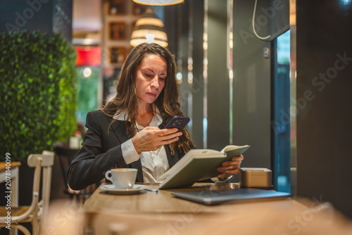 Tableau sur toile Businesswoman managing work and connecting online in a cafe