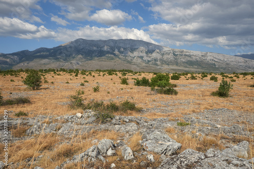 Fotografía Rocky karst plateau below a limestone mountain ridge