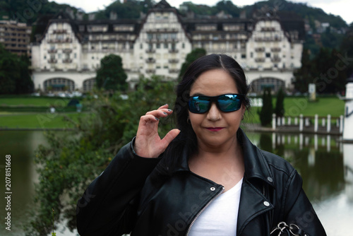 Stylish Woman wearing sunglasses in front of historic building palace called Quitandinha, in Petropolis, Brazil