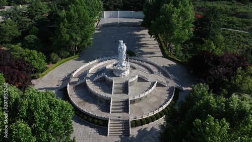 Aerial view of the circular plaza with monument statue at Rizhao Martyrs Cemetery surrounded by green trees and stone railings