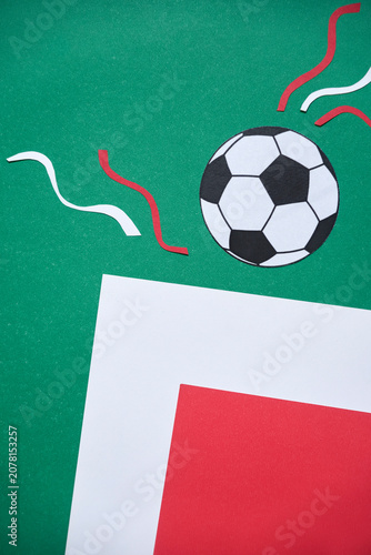 A football paper design in the colors of the Mexican flag: green, white, and red. The composition includes a soccer ball, celebration streamers and copy space.