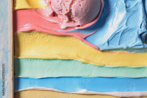 A close-up background showing the texture of different flavours and colours of creamy ice cream.