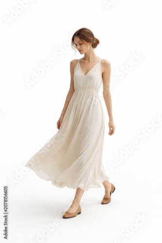 Elegant woman in flowing white dress on white background.