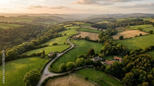 Aerial view of rolling green countryside with winding roads and farmhouses