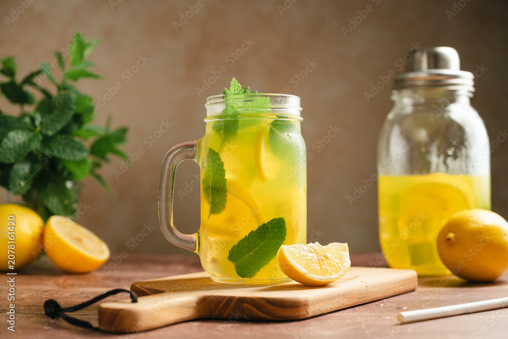 Fototapeta premium Homemade iced lemonade drink, with fresh mint leaves served in mason jar mug, rustic summer cold drink concept, rustic still life