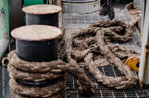 Tableau sur toile The old mooring rope is secured on the ship's bollard to keep the vessel alongsi