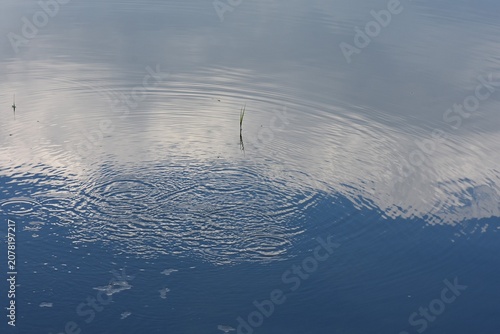 White clouds reflecting in calm lake waters 