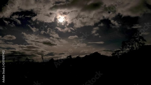 Clouds drifting on front of the almost full moon at the west