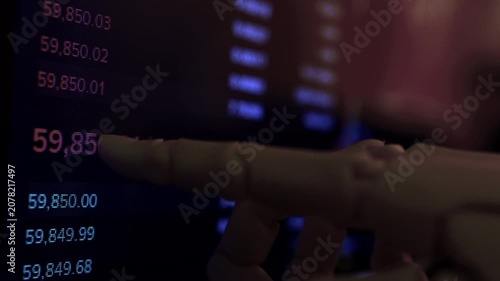 Futuristic humanoid cyborg hand scanning  financial data on pc screen. Dark atmospheric high-tech office background, macro lens shot. Ideal for cybersecurity and neural network themes.