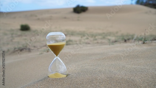 Hourglass filling with sand, symbolizing time running out for climate change action, global warming, drought, and the urgent need for environmental sustainability