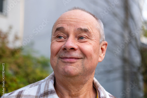 happy positive caucasian mature man 60-65 years old smiling on green natural background, good mood, age-related changes, mental human health