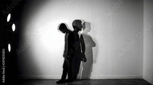 A conceptual black and white artistic silhouette portrait representing psychological struggle and internal emotional conflict of man