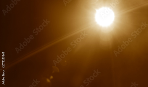 abstract photo of light burst among trees and glitter bokeh. image is blurred. yellow golden bokeh pattern background. Real optical lens flare on black backdrop. sunrays, sun rays beam, burst, sunbeam