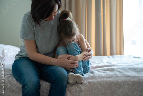 Fotografie Loving young mother touching upset little daughter, expressing support, young mu