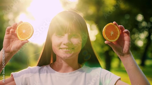 Portrait young girl close-up ripe oranges. Cheerful girl holds juicy oranges in hands. Healthy fruits from garden summer. Happy healthy people. Concept healthy nutrition. Natural vitamins for people