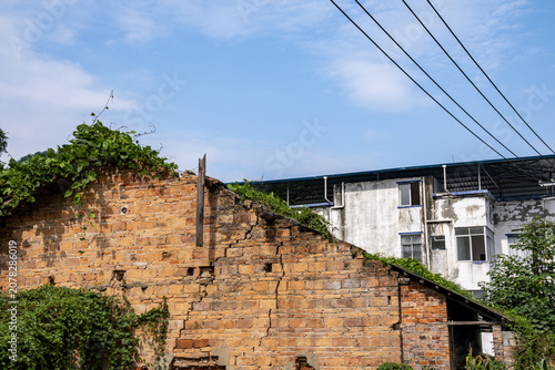 Obraz na plátne Crumbling old rural house beside weathered residential apartment building in Guangxi China