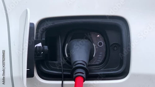 Electric car charge, EV Car or Electric vehicle at charging station with the power cable supply plugged in. Eco-friendly sustainable energy concept.