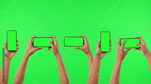 Studio shot of hand shows mobile smartphone with green screen in vertical position isolated on background. Mock up mobile for Infographic Global Business web site design app, - Clipping Path