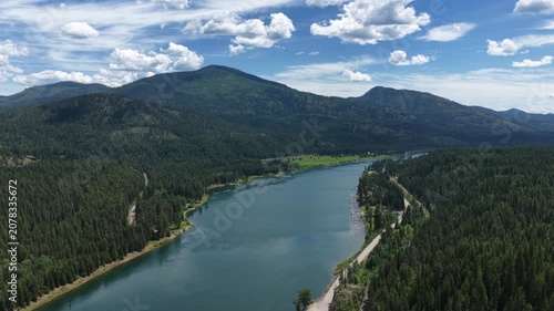Aerial of Pend Oreille river flowing through forested valley near Ruby Washington with dense coniferous forests on sunny summer day