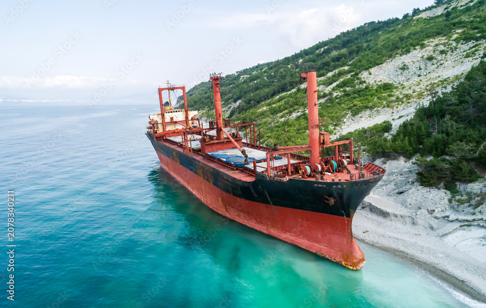 Obraz premium Aerial view of an abandoned bulk-carrier dry cargo ship washed ashore after a storm