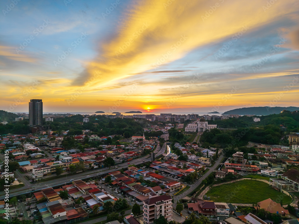 Fototapeta premium Aerial view of Kota Kinabalu city at sunset, Sabah, Malaysia, with vibrant golden sky.