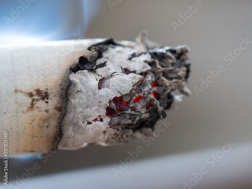 Принти на полотні Macro close-up of a lit cigarette with glowing embers and ash, representing smoking addiction and health hazards