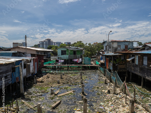 Foto Stilt houses in Sembulan water village, Kota Kinabalu, Sabah, with the city skyline in the background