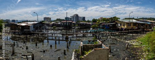 Bild auf Leinwand Stilt houses in Sembulan water village, Kota Kinabalu, Sabah, with the city skyline in the background