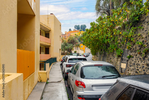 Foto A narrow residential hillside street leading to the medieval old town with the Cemetery of the Old Château at the top in Menton, France