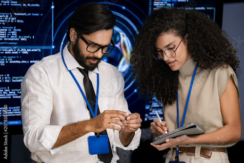 Foto A diverse team strategizes in a high tech meeting beside a glowing spherical display in a dark modern studio, amid the soft hum of a busy operations room in a sleek, contemporary research