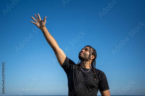 Quadro su tela Man reaching out to blue sky striving for success