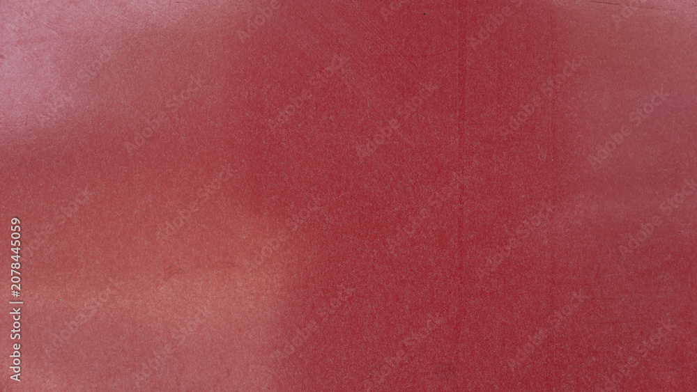 Fototapeta premium Background texture displaying a solid dark red painted wooden plank surface. The matte finish features subtle gradients and soft lighting across the plain area.