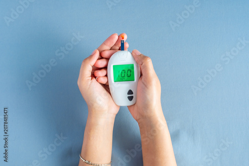 Bild auf Leinwand Woman's hands checking diabetes and hyperglycemia with digital blood sugar meter